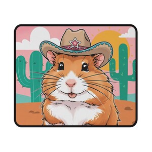 May include: A cartoon hamster wearing a turquoise and brown cowboy hat with a pink star on the hat. The hamster is smiling and has a pink tongue sticking out. The background is a desert scene with two green cacti and a yellow sun.