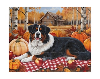 Könnte beinhalten: Ein Puzzlespiel mit einem Berner Sennenhund, der auf einer rot-weiß karierten Decke liegt. Der Hund ist von Kürbissen, Äpfeln und Herbstblättern umgeben. Im Hintergrund sind eine Hütte und Birken zu sehen.
