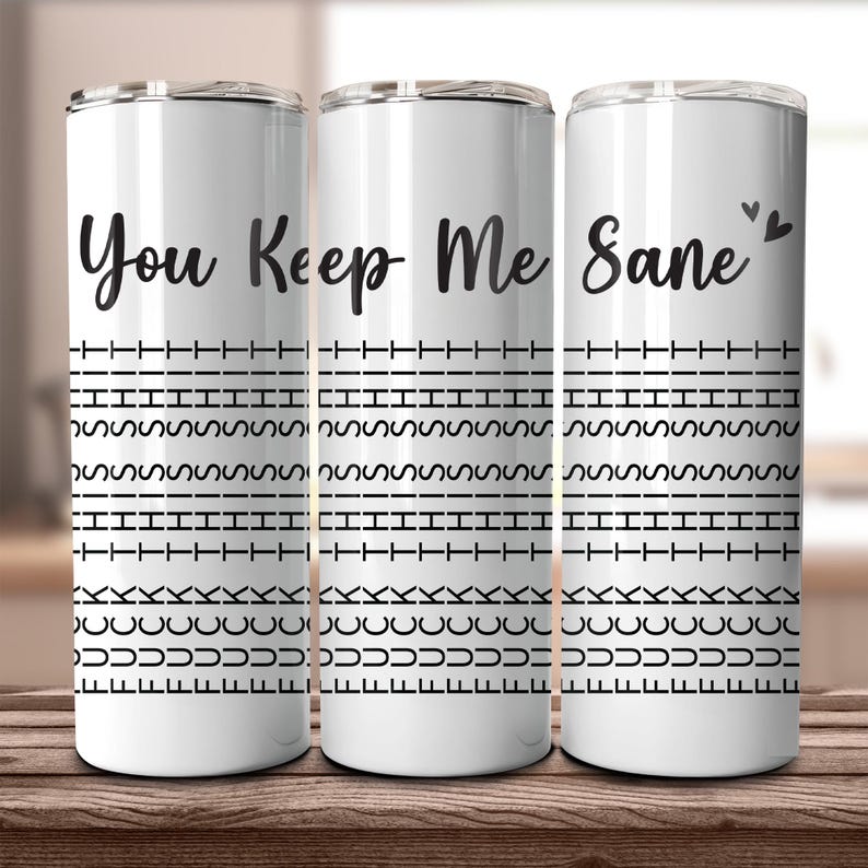 May include: Three white insulated tumblers with black text that reads "You Keep Me Sane". The tumblers have a repeating black pattern of dashes, squiggles, and curved lines. Two small black hearts are above the word "Sane".