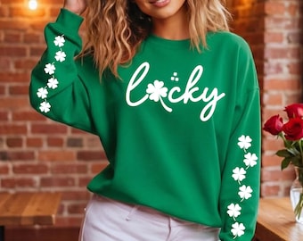 May include: Green sweatshirt with the word "Lucky" in white script, accented with shamrocks. White shamrock clusters adorn the sleeves. The sweatshirt is a vibrant green color.