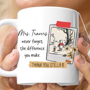 Könnte beinhalten: Weiße Keramiktasse mit einer Illustration von Winnie Puuh und Ferkel. Auf der Tasse steht "Mrs. Travers, vergiss nie den Unterschied, den du machst. Danke, Stella B."