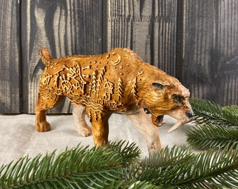 Puede incluir: Una escultura de madera de un tigre dientes de sable con intrincados tallados de árboles, estrellas y otros diseños inspirados en la naturaleza. La escultura está pintada en un color marrón cálido y tiene un aspecto realista.