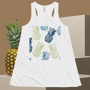 May include: White tank top with a blue and green pineapple pattern.