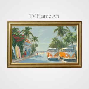 Puede incluir: Una impresión artística enmarcada titulada "TV Frame Art" representa una escena playera soleada con dos autobuses Volkswagen naranja y blanco estacionados en una calle bordeada de palmeras. Tablas de surf apoyadas contra un edificio.