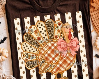 May include: A dark brown t-shirt featuring a graphic of a turkey with a pink bow. The turkey's tail feathers display patterns of polka dots, leopard print, and autumn flowers. The turkey's body has a brown and white plaid pattern.