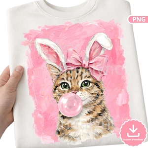 May include: White sweatshirt featuring a tabby cat wearing bunny ears and a pink bow, blowing a bubblegum bubble. The cat is set against a pink painted background. The design is a digital illustration.