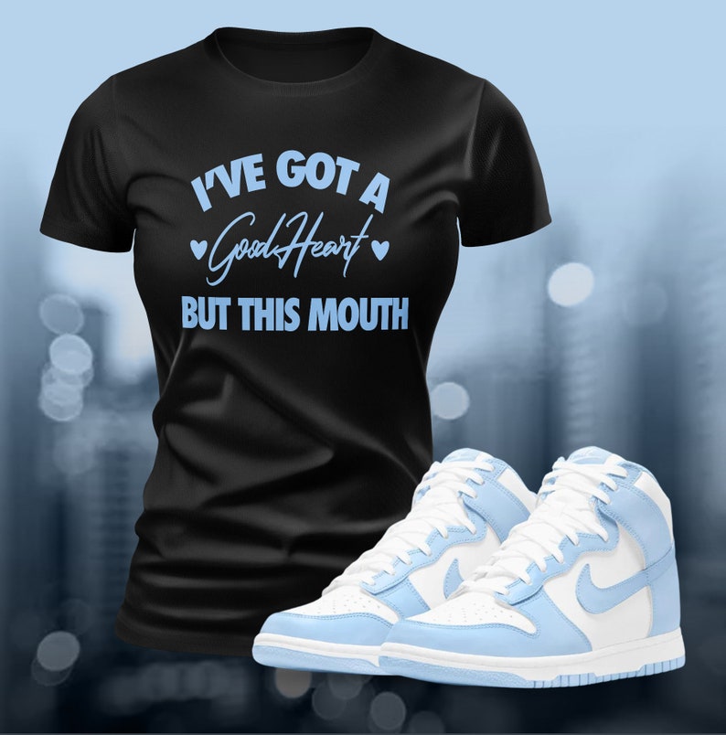 May include: Black t-shirt with the text "I've got a good heart but this mouth" in light blue.  The t-shirt is paired with light blue and white high-top sneakers.