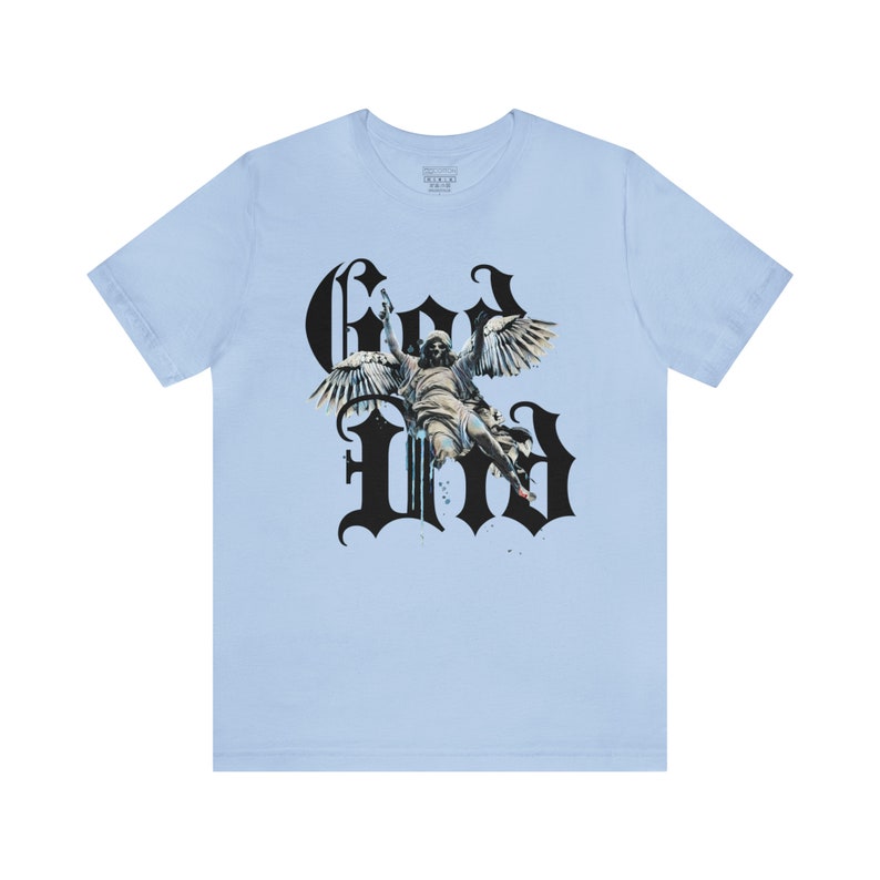 May include: Light blue t-shirt featuring a black graphic print of an angel with wings and the word "God" in a gothic font.