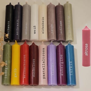 May include: Assortment of 16 candles in various colors, including jade green, yellow, red, dark red, pink, lavender, purple, blue, black, gray, white, ivory, taupe, brown, and green. The candles are labeled with their color names in German.