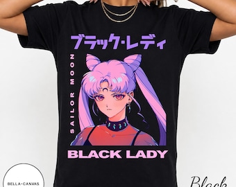 Może przedstawiać: Czarny t-shirt z krótkim rękawem z nadrukiem graficznym postaci Black Lady z Sailor Moon. Wzór zawiera różowe włosy, ciemny choker oraz napis "SAILOR MOON" w pionie i "BLACK LADY" w poziomie w kolorze różowym.