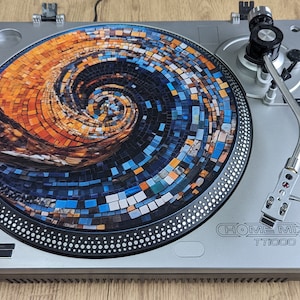 May include: Silver Home Mix TT1000 turntable with a mosaic design on the platter. The mosaic features a spiral pattern in shades of orange, blue, and white. The turntable has a tonearm, pitch adjust, and start/stop controls.
