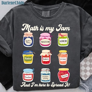 Może przedstawiać: Ciemnoszara bluza z napisem "Math is my Jam" i ilustracjami słoików z dżemem oznaczonych terminami matematycznymi, takimi jak "Fractions" i "Calculus". Zawiera również frazę "And I'm here to Spread It!".