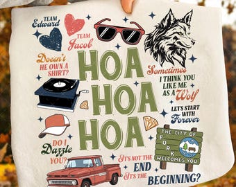 May include: A white blanket with various graphics and text. The design includes a red pickup truck, a wolf head, sunglasses, and the words "HOA" in large green letters. Other text includes "Team Jacob" and "The City of Forks Welcomes You."