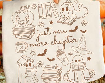 Könnte beinhalten: Beiger Stoff mit brauner Illustration mit einem Kürbis, Geistern, Büchern, einem Hexenhut, einer Kaffeetasse und dem Text "just one more chapter". Das Design umfasst Sterne, Fledermäuse und Blumen.