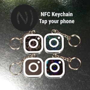Puede incluir: Cuatro llaveros NFC cuadrados con un diseño de logotipo de cámara de Instagram. Cada llavero tiene un llavero y una cadena plateados. Los llaveros tienen diferentes patrones, incluidos diseños geométricos y brillantes. El texto "NFC Keychain Tap your phone" está en el fondo.
