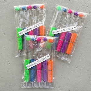 May include: Several packs of neon-colored pens in clear plastic packaging. Each pen has a different color, including green, blue, pink, purple, and orange. The text "Neon Multi-Pack" is printed on a white label on each package.