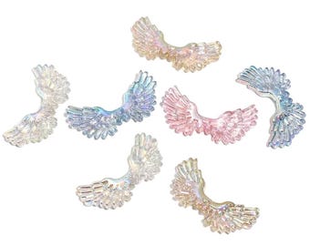 May include: Assortment of iridescent angel wings in various colors, including pink, blue, and white. The wings are made of a translucent material and have a delicate, ethereal look.