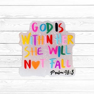 May include: A colorful, glittery, rectangular charm with the words "GOD IS WITHIN HER SHE WILL NOT FALL" in various colors. The text "Psalm 46:5" is written below the quote. The charm has a white background.