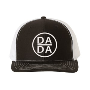 May include: Black and white trucker hat with a white circle logo that says "DA DA" in a bold font.