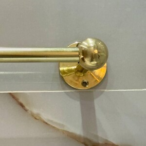 Side profile of the wall-mounted towel bar showing sturdy end post and set screw. Slim, space-saving design coordinates with brass faucets, shower sets, and towel rings; patina-ready finish.