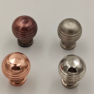 Puede incluir: Cuatro pomos de armario con un dise&ntilde;o redondo y estriado. Dos son de cobre, uno es de n&iacute;quel cepillado y uno es de n&iacute;quel pulido.