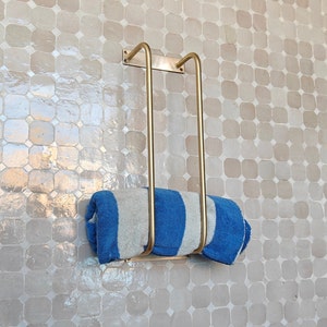 Close-up of antique brass towel bar showing unlacquered solid brass finish and sturdy mounting brackets; perfect for hanging hand towels, bath towels, or washcloths; sleek minimalist design blends farmhouse, industrial, and French-country styles.