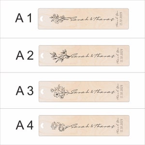 Pode incluir: Quatro marcadores de p&aacute;gina de madeira com um design floral e o texto "Sarah & Tharas" e "Obrigado 11.10.2023".