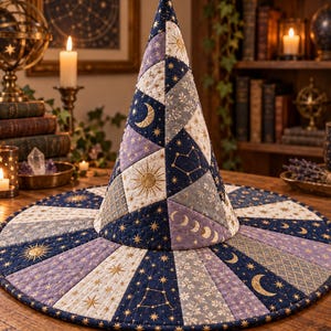 May include: A quilted witch hat featuring a patchwork design of dark blue, light blue, and purple fabric panels. The fabric is decorated with gold foil celestial motifs including suns, moons, stars, constellations, and lunar phases.