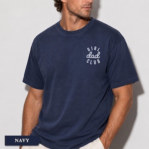 Puede incluir: Camiseta azul marino con el texto blanco "GIRL dad CLUB". La camiseta tiene cuello redondo y mangas cortas. La tela parece suave y c&oacute;moda.