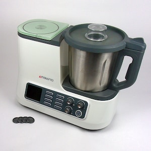 Könnte beinhalten: Ein weiß-grauer Ambiano-Küchenroboter mit einer Edelstahl-Rührschüssel und einem transparenten Deckel. Das Bedienfeld hat ein digitales Display und mehrere Tasten und Drehregler. Vor dem Gerät liegen eine Reihe schwarzer Scheiben.