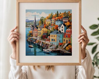 May include: A framed art print showing a vibrant coastal town. The image includes buildings in various colours, a church with a spire, boats on the water, and autumn foliage. The frame is a light wood colour.