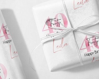 May include: White gift wrap with a pink watercolor design of the number 40 and the text "Forty". The wrap is tied with a silver ribbon and has the name "Leila" written on it.  Happy Birthday Leila.