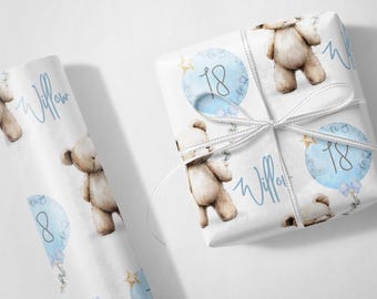 May include: White gift wrap with a repeating pattern of teddy bears, blue balloons with the number 18, and the name "Willow" in a script font. The wrapped gift is tied with a white ribbon.