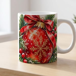May include: A white ceramic mug featuring a vibrant illustration of a glossy red Christmas ornament decorated with a gold snowflake pattern, topped with a large red bow, and surrounded by green pine branches and small red holly berries.