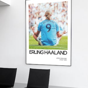 May include: A black and white poster featuring a soccer player in a blue jersey with the number 9 on the back. The player is sitting in a yoga pose with their back to the camera. The poster has the text "Erling Haaland" and "Leeds, England 21 July 2000" printed on it.