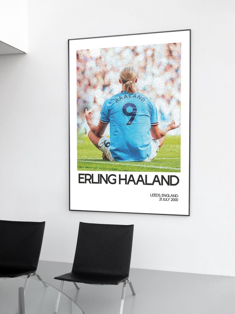 May include: A black and white poster featuring a soccer player in a blue jersey with the number 9 on the back. The player is sitting in a yoga pose with their back to the camera. The poster has the text "Erling Haaland" and "Leeds, England 21 July 2000" printed on it.