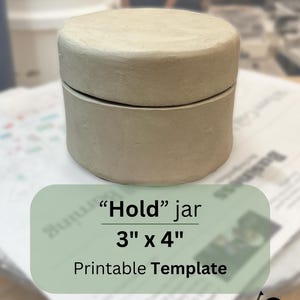 Peut inclure: Un pot en céramique beige avec un couvercle, étiqueté "Hold" jar 3" x 4" Printable Template.