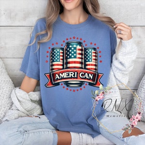 May include: A blue t-shirt with a graphic of three beer cans with the American flag design. The cans are surrounded by stars and a banner that reads "Ameri Can".