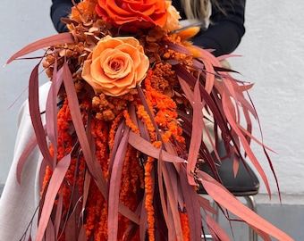 Ramo de novia en cascada de terracota, flores secas de color naranja quemado, arreglo floral de boda bohemio de otoño.