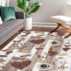 May include: A rectangular coffee-themed rug with a light brown wood-grain pattern. The rug features coffee cups, espresso, coffee beans, and the words "espresso" and "coffee" in a decorative font. The rug is placed in a living room setting.