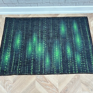 May include: A black and green rug with a digital pattern of green 1s and 0s on a black background.
