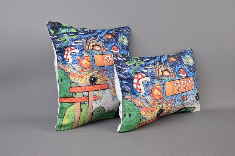 Op de afbeelding: Twee decoratieve kussens met een blauw, groen, oranje en geel Starry Night-ge&iuml;nspireerd ontwerp met een videogamethema. De kussens hebben een witte achtergrond en bevatten verschillende videogamepersonages en -objecten.