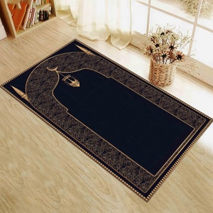 Könnte beinhalten: Ein schwarzer Gebetsteppich mit goldener Umrandung und einem komplizierten Design. Der Teppich zeigt einen traditionellen islamischen Torbogen mit einer Mondsichel und einer Laterne.