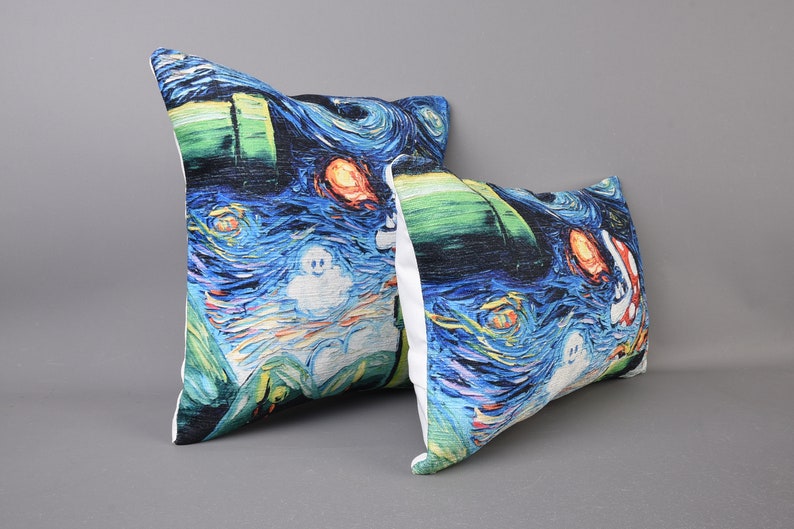 May include: Two decorative throw pillows with a blue, green, and white starry night print. The pillows feature a ghost and a red and orange fish.