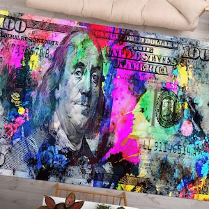 May include: A colourful abstract rug featuring a $100 bill with Benjamin Franklin's portrait. The bill is covered in vibrant splashes of paint in shades of blue, green, pink, yellow, and orange.