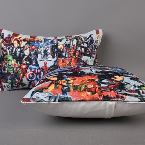 May include: Two decorative throw pillows with a white background and a colorful print of various superheroes. The print features a variety of characters, including Captain America, Iron Man, Thor, and Hulk.