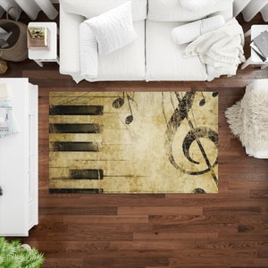 May include: A vintage-style rug with a musical theme. The rug features a black and white piano keyboard, a treble clef, and musical notes on a beige background with a distressed look.