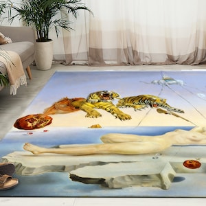 Puede incluir: Una alfombra surrealista que presenta a una mujer desnuda tumbada sobre una formación rocosa, dos tigres saltando en el aire y una gran granada roja. El fondo es un cielo azul claro con nubes blancas y un objeto blanco flotante en forma de cuerda.
