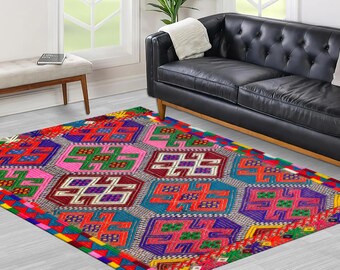 May include: A colorful rug with a geometric pattern in shades of red, pink, green, blue, and yellow. The rug has a white background and features a repeating design of squares and diamonds.