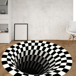 Puede incluir: Una alfombra a cuadros en blanco y negro con una ilusión óptica 3D de un agujero en el centro. La alfombra está sobre un suelo de madera en una habitación con una silla blanca y una estantería blanca.